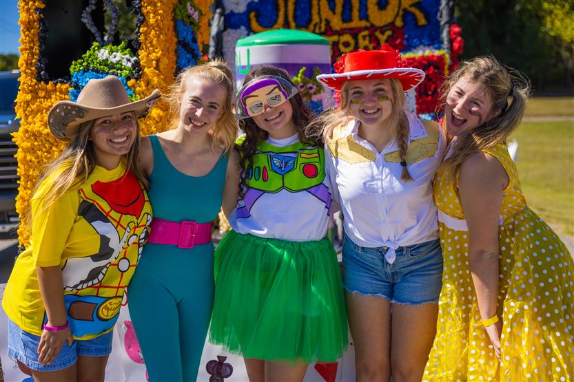 A group of girls smiles at a homecoming parade